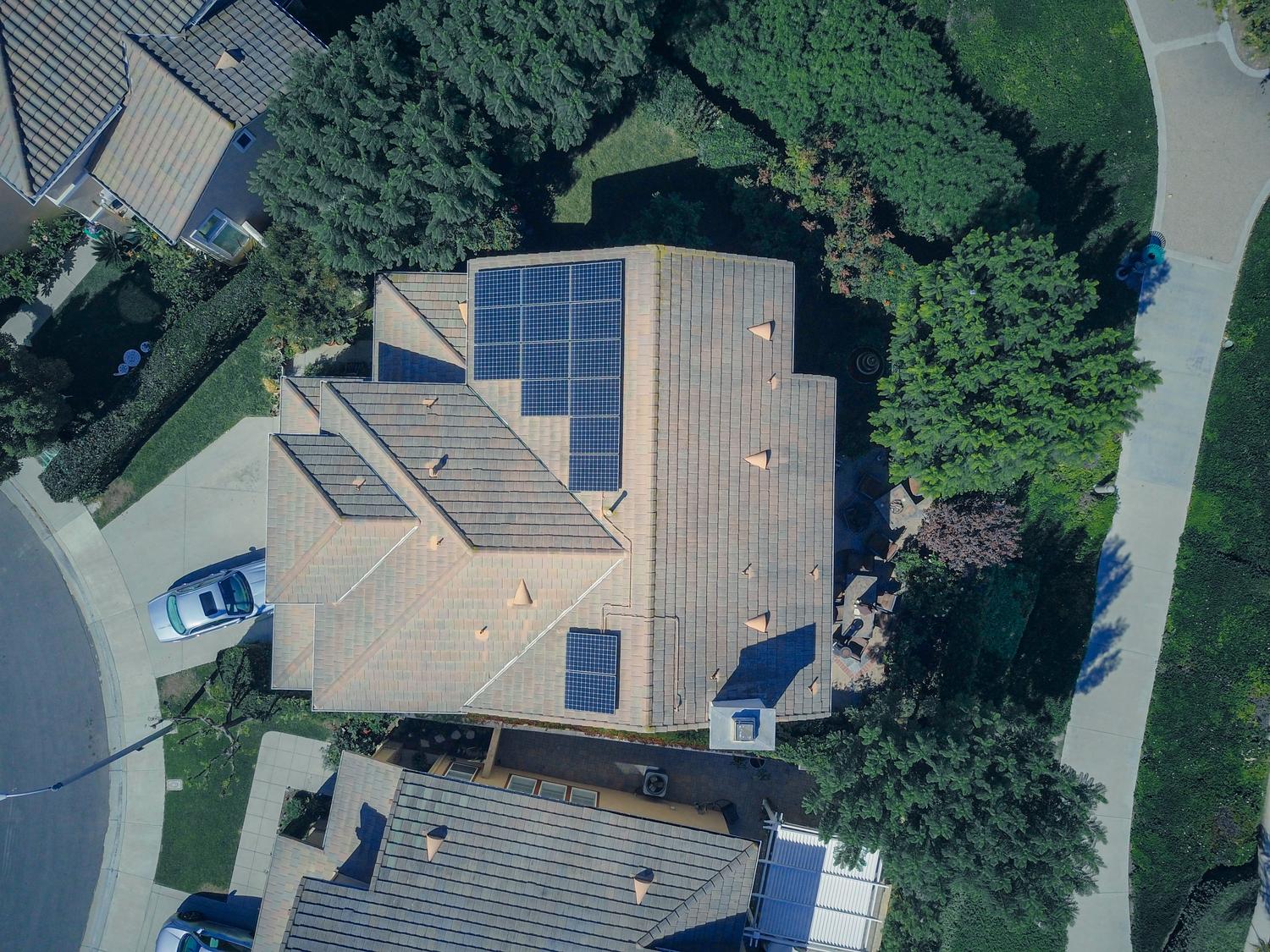 Vista aérea de una casa equipada con paneles solares, base del sistema de energía distribuida.