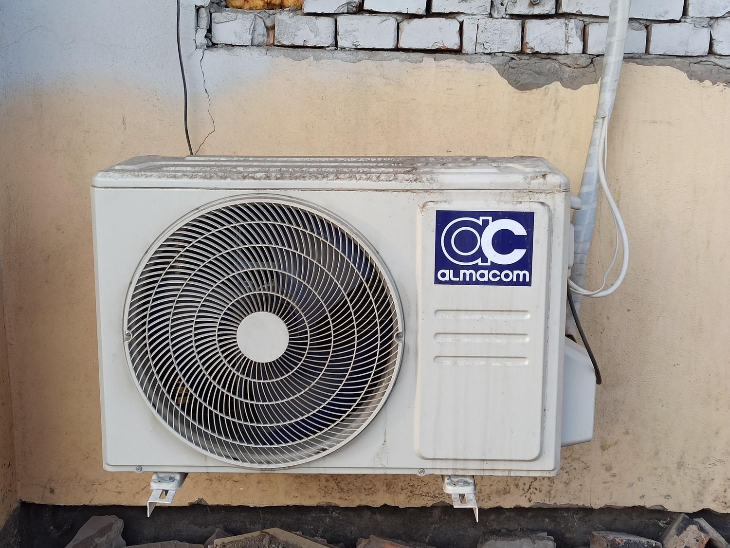 Unidad exterior de compresor y condensador de un sistema split instalada en la fachada de un edificio.