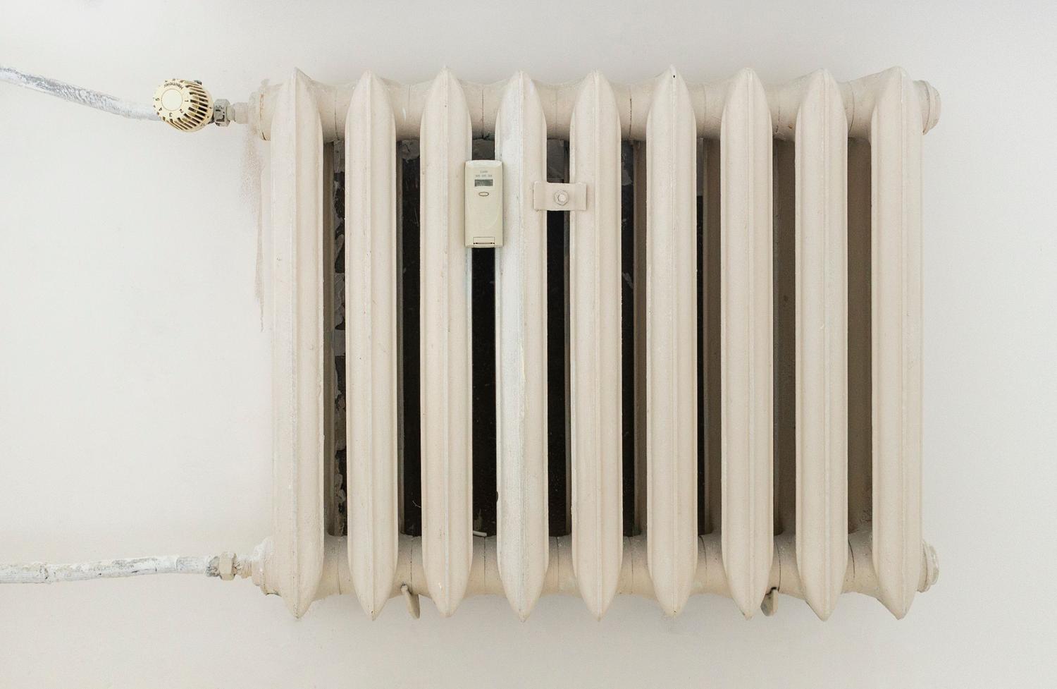 Radiador de calefacción blanco instalado en una pared blanca minimalista