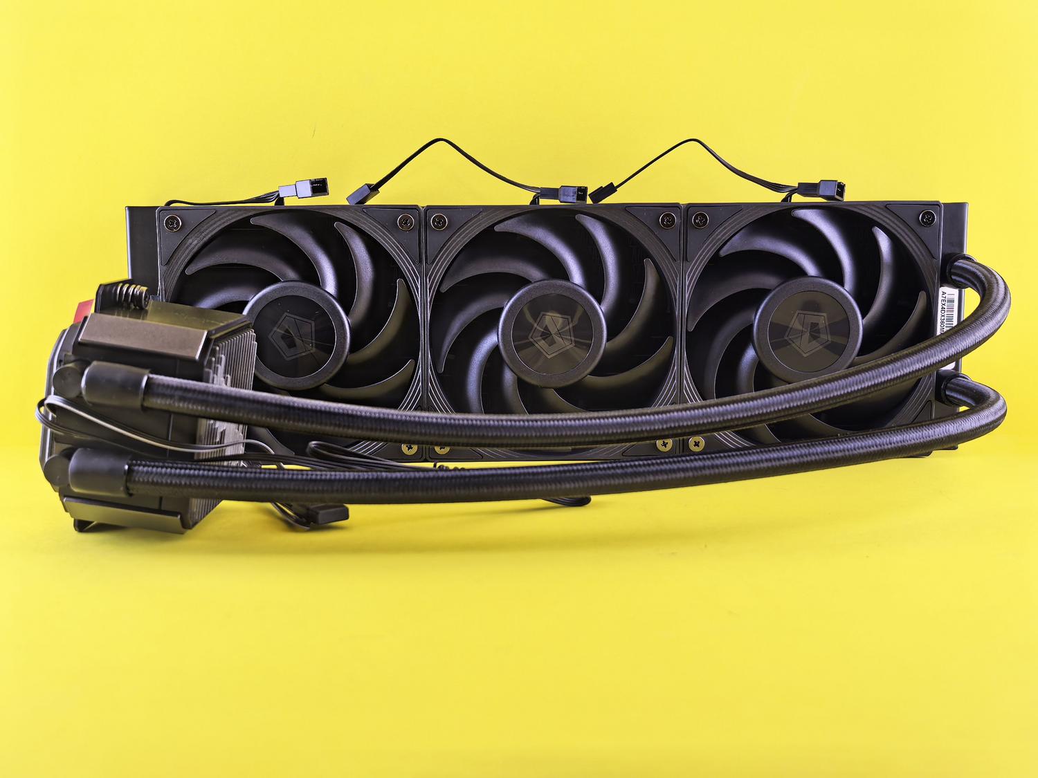 Sistema de refrigeración líquida moderno con radiador de triple ventilador sobre un fondo amarillo vibrante.