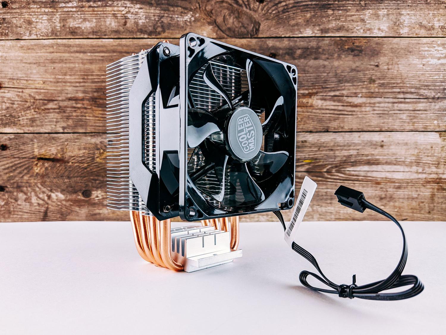 Ventilador de CPU y disipador de calor estándar sobre una superficie de madera, ejemplificando la refrigeración por aire clásica.