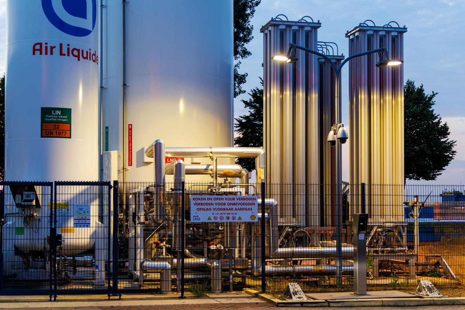Instalación industrial de gas al atardecer, simbolizando la escala de producción y almacenamiento de hidrógeno verde.
