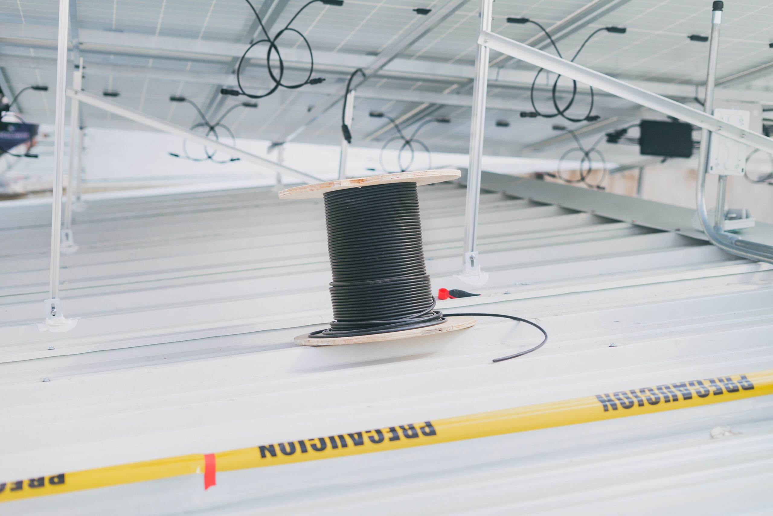 Montaje del cableado eléctrico y bobina de cables para un sistema de paneles solares fotovoltaicos en una azotea.
