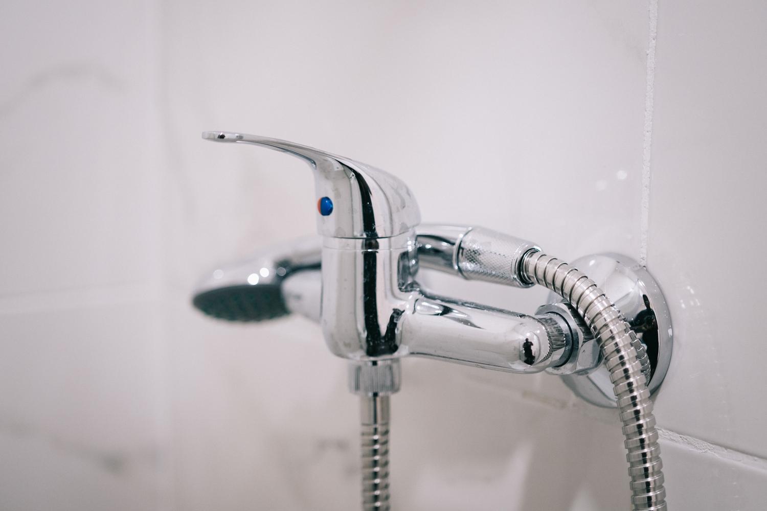 Detalle de un grifo monomando para ducha cromado con mando único para control de temperatura y caudal.