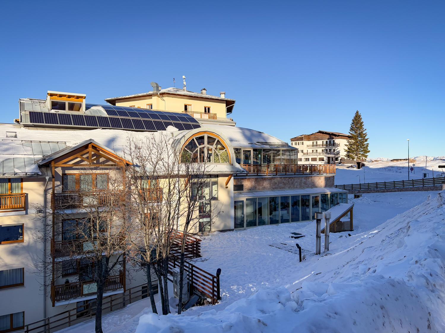 Hotel de montaña con paneles solares en el tejado, ejemplo de turismo sostenible en entornos naturales Hotel de montaña con paneles solares en el tejado, ejemplo de turismo sostenible en entornos naturales