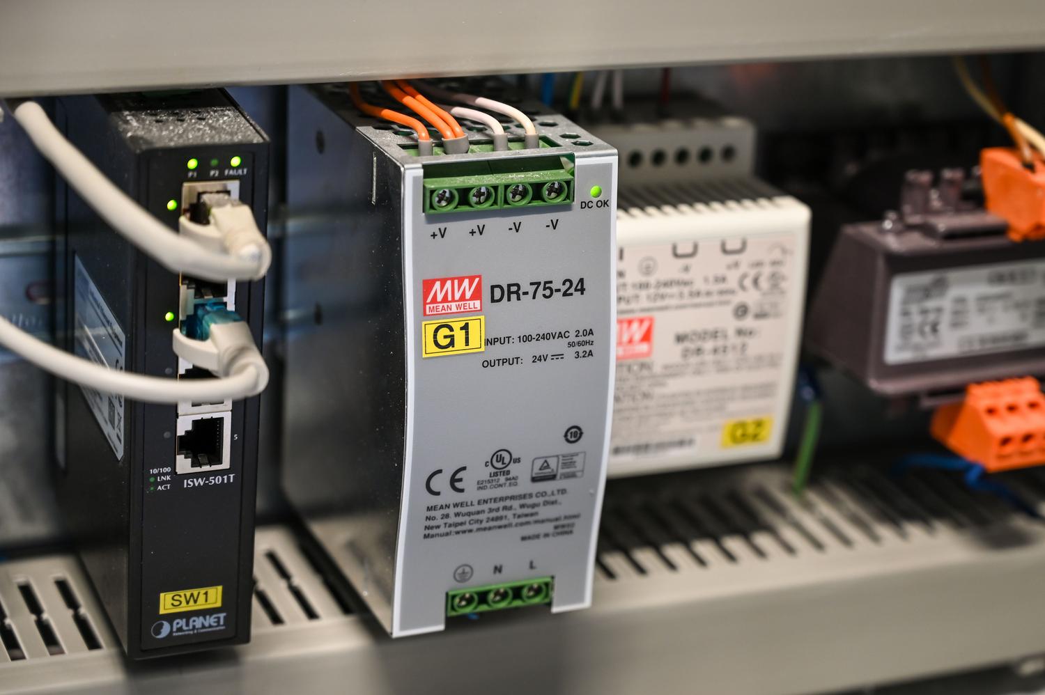 Componentes electrónicos y cableado interno de un sistema de automatización industrial, representando los sensores y la lógica de control del sistema AWTS.