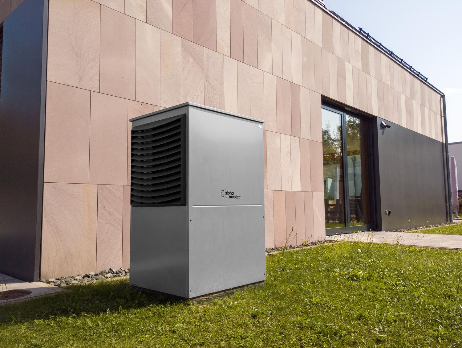 Unidad exterior de bomba de calor aerotermia moderna instalada en el exterior de una vivienda contemporánea.