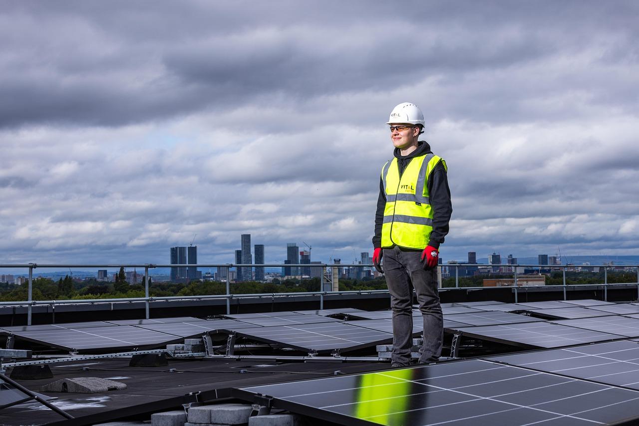 Técnico especializado supervisando una instalación de paneles solares en una cubierta industrial.