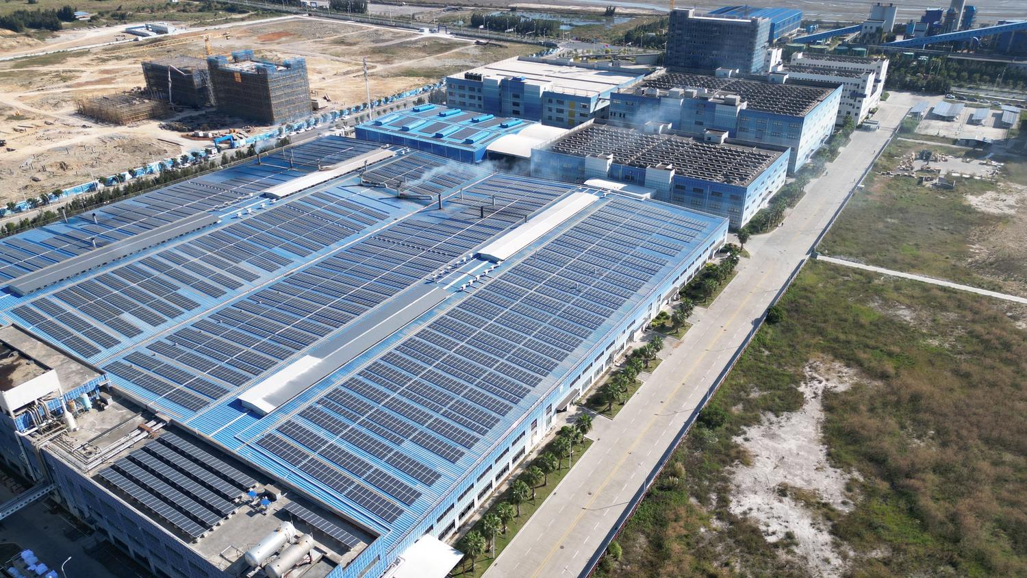 Vista aérea de una nave industrial con el tejado completamente cubierto de paneles solares fotovoltaicos. Vista aérea de una nave industrial con el tejado completamente cubierto de paneles solares fotovoltaicos.