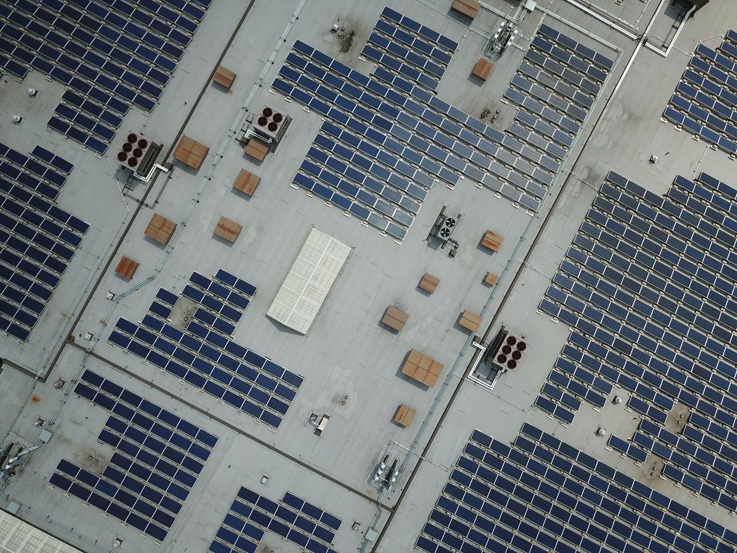 Detalle cenital de la integración de paneles solares y sistemas de climatización industrial en una cubierta.