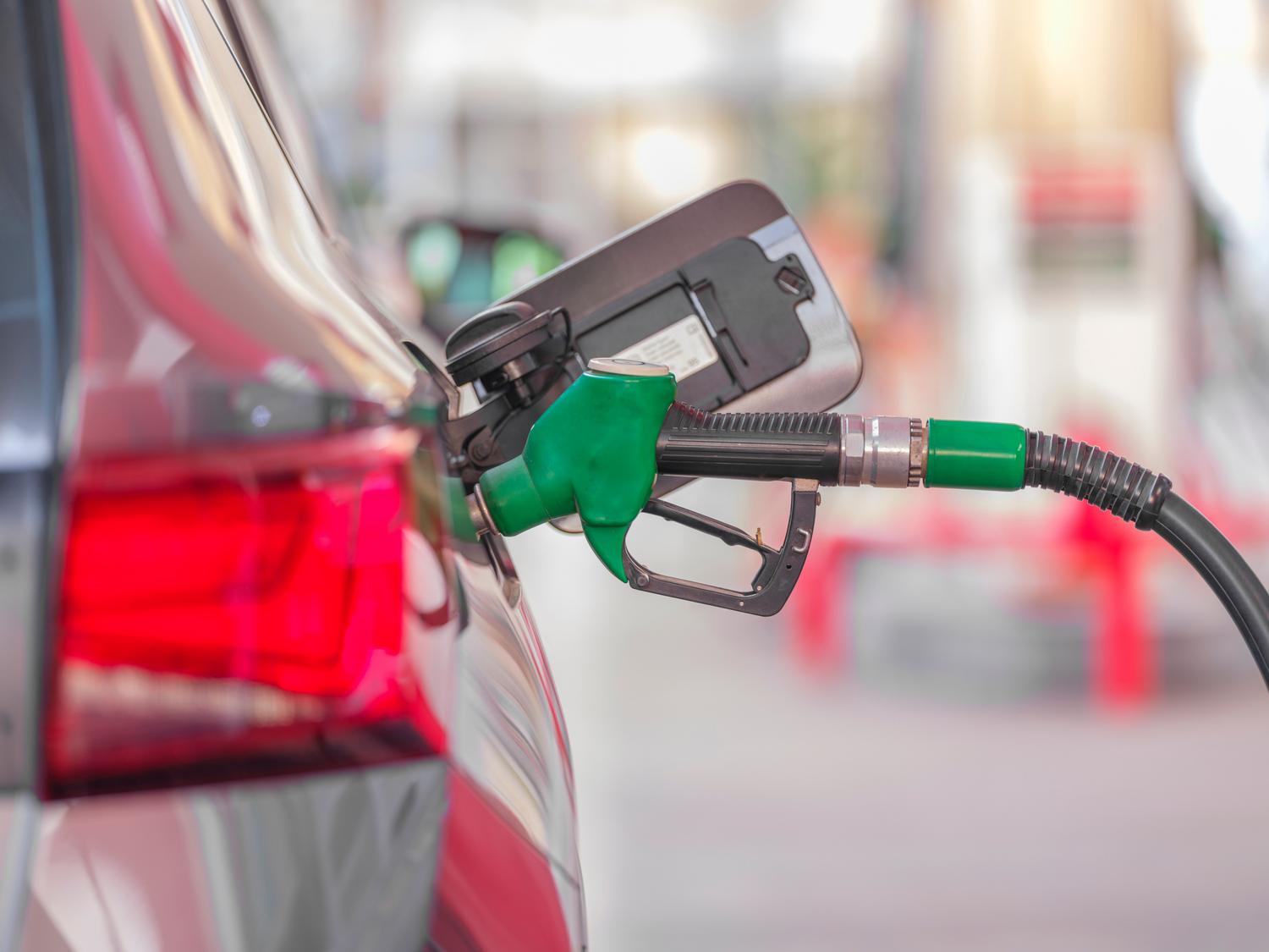Primer plano de boquilla de gasolina repostando un vehículo en gasolinera
