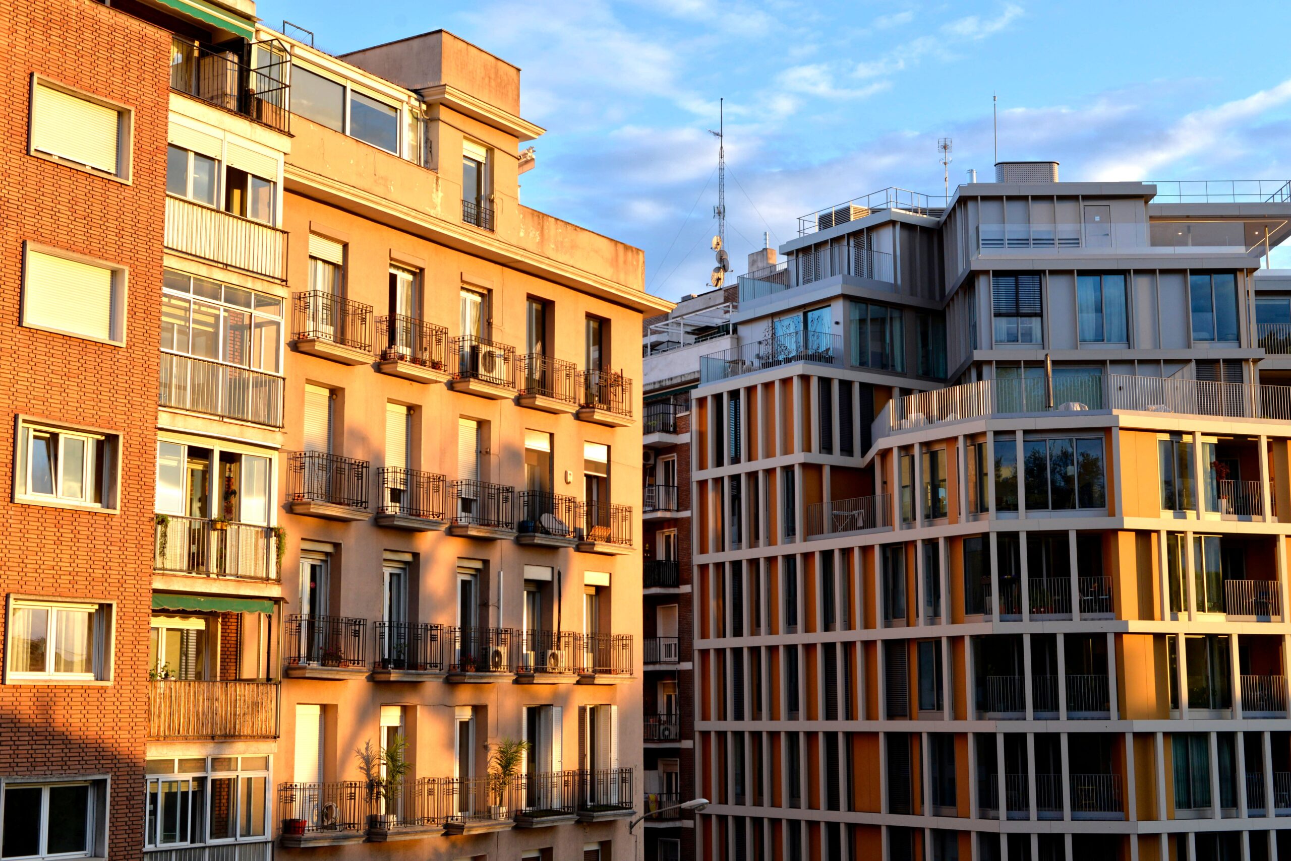 Fachadas de edificios residenciales que combinan arquitectura clásica y moderna, ilustrando la necesidad de rehabilitación energética.