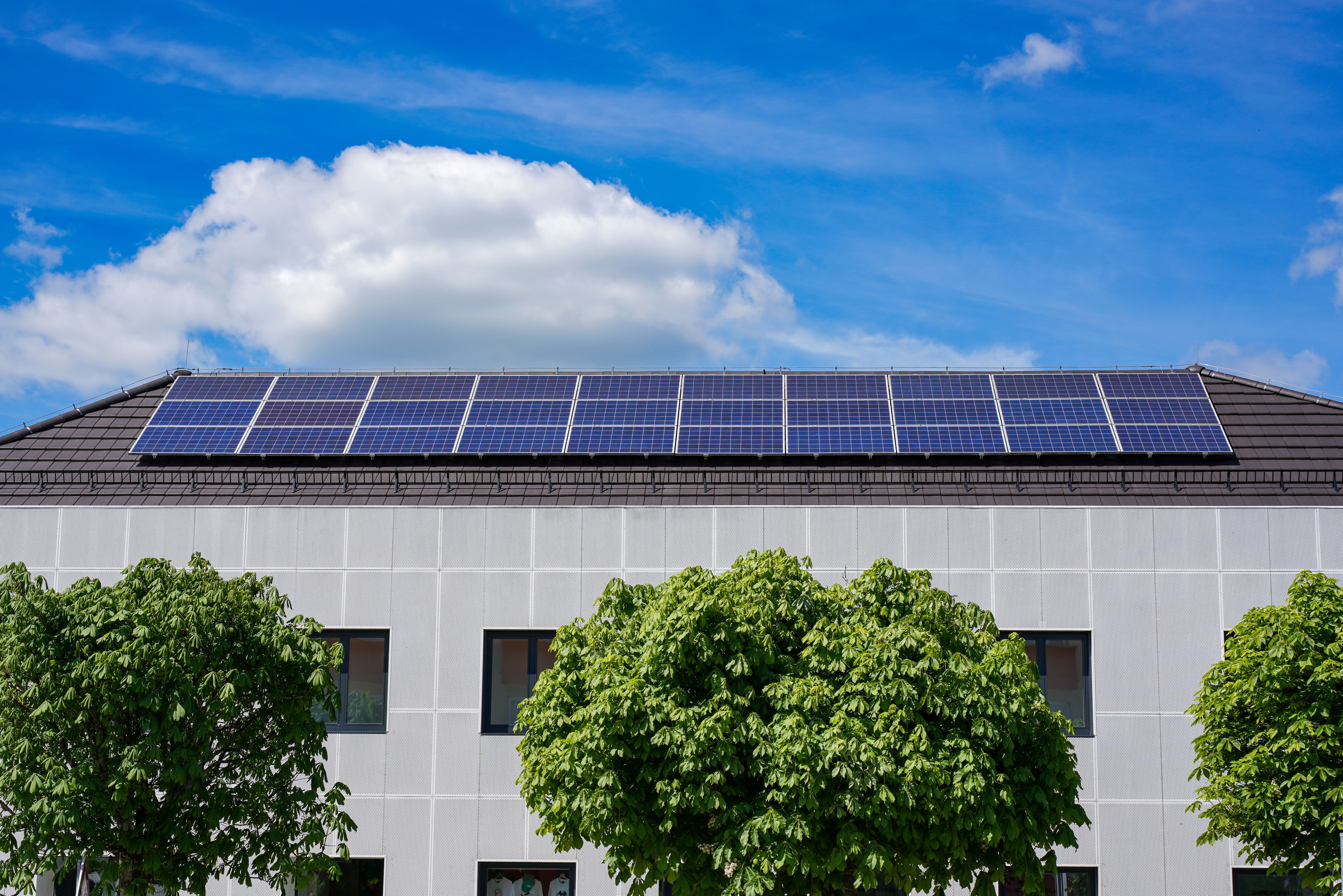 Edificio residencial sostenible con paneles solares y entorno verde, ejemplo de arquitectura de cero emisiones. Edificio residencial sostenible con paneles solares y entorno verde, ejemplo de arquitectura de cero emisiones.
