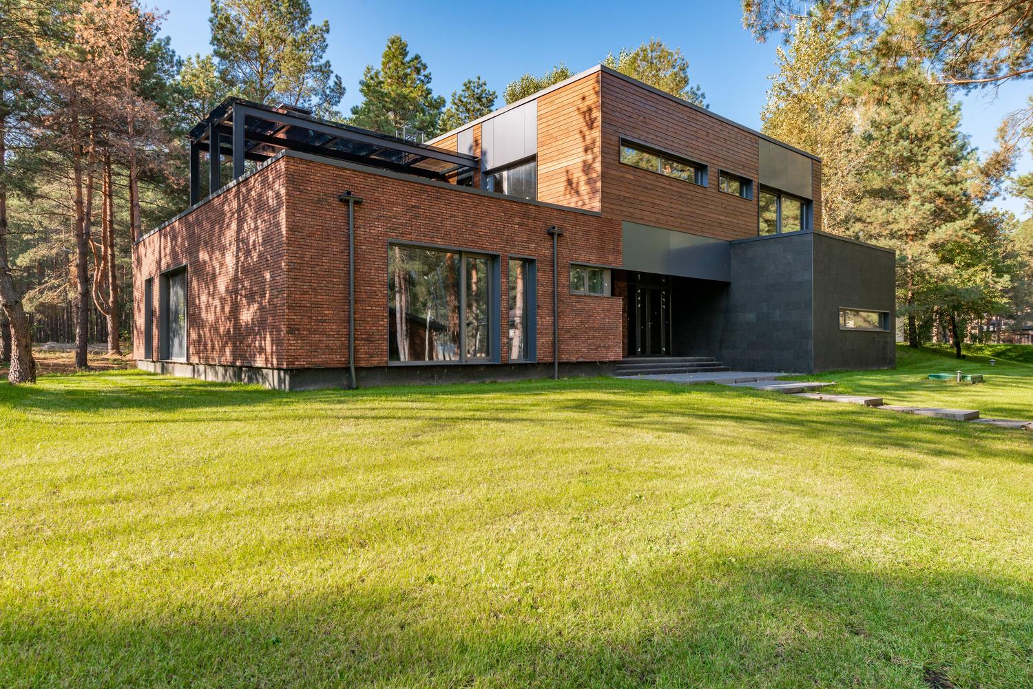 Casa de ladrillo contemporánea con grandes ventanales de alta eficiencia energética.
