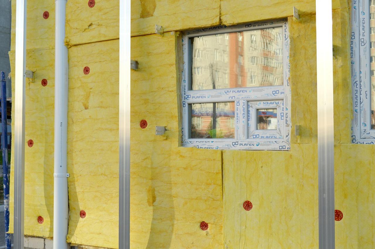 Instalación de aislamiento térmico exterior en la fachada de una vivienda utilizando lana mineral.