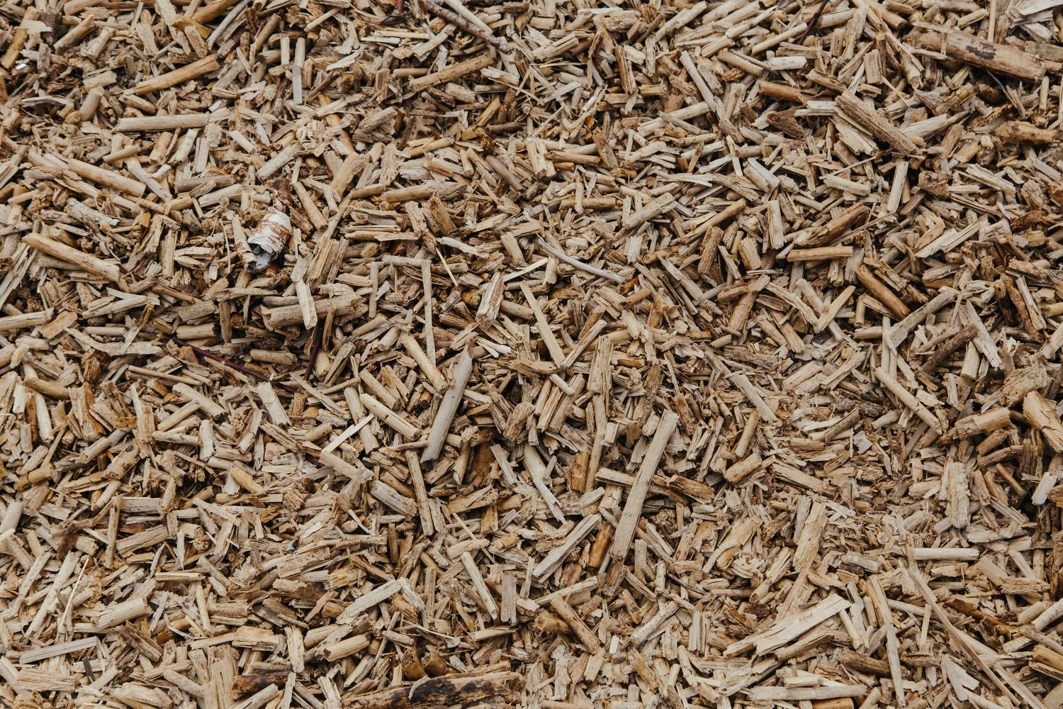 Primer plano detallado de astillas de madera, combustible principal para calderas de biomasa.
