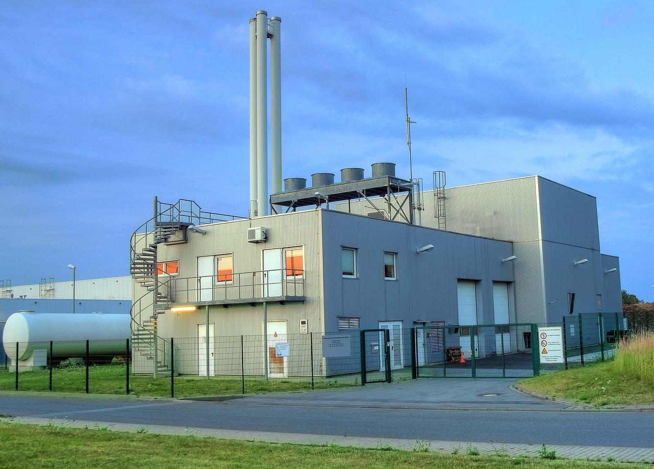 Planta industrial de calefacción de biomasa con chimeneas y sistemas de combustión.