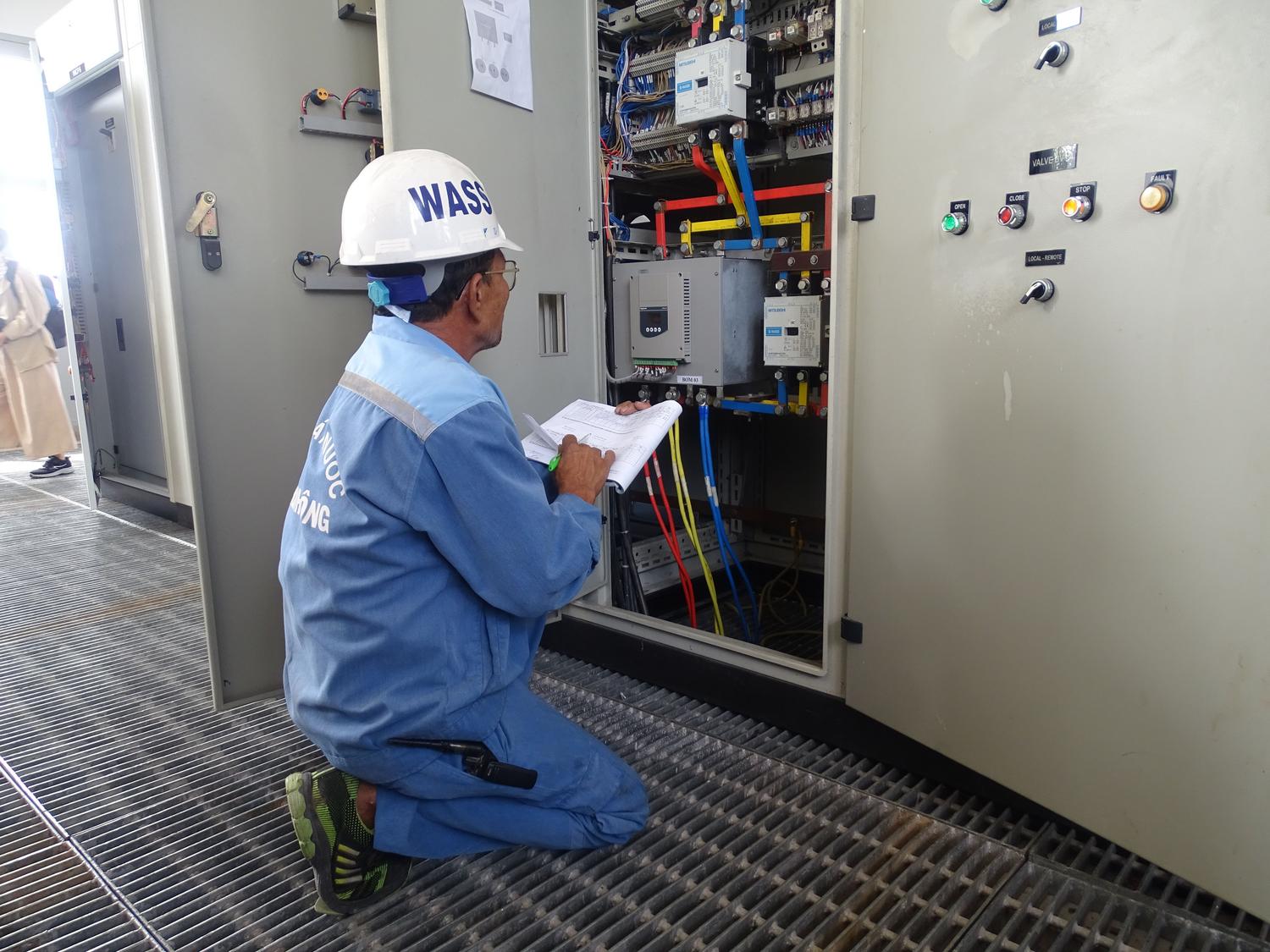 Técnico especializado inspeccionando un panel de control eléctrico industrial para mantenimiento preventivo