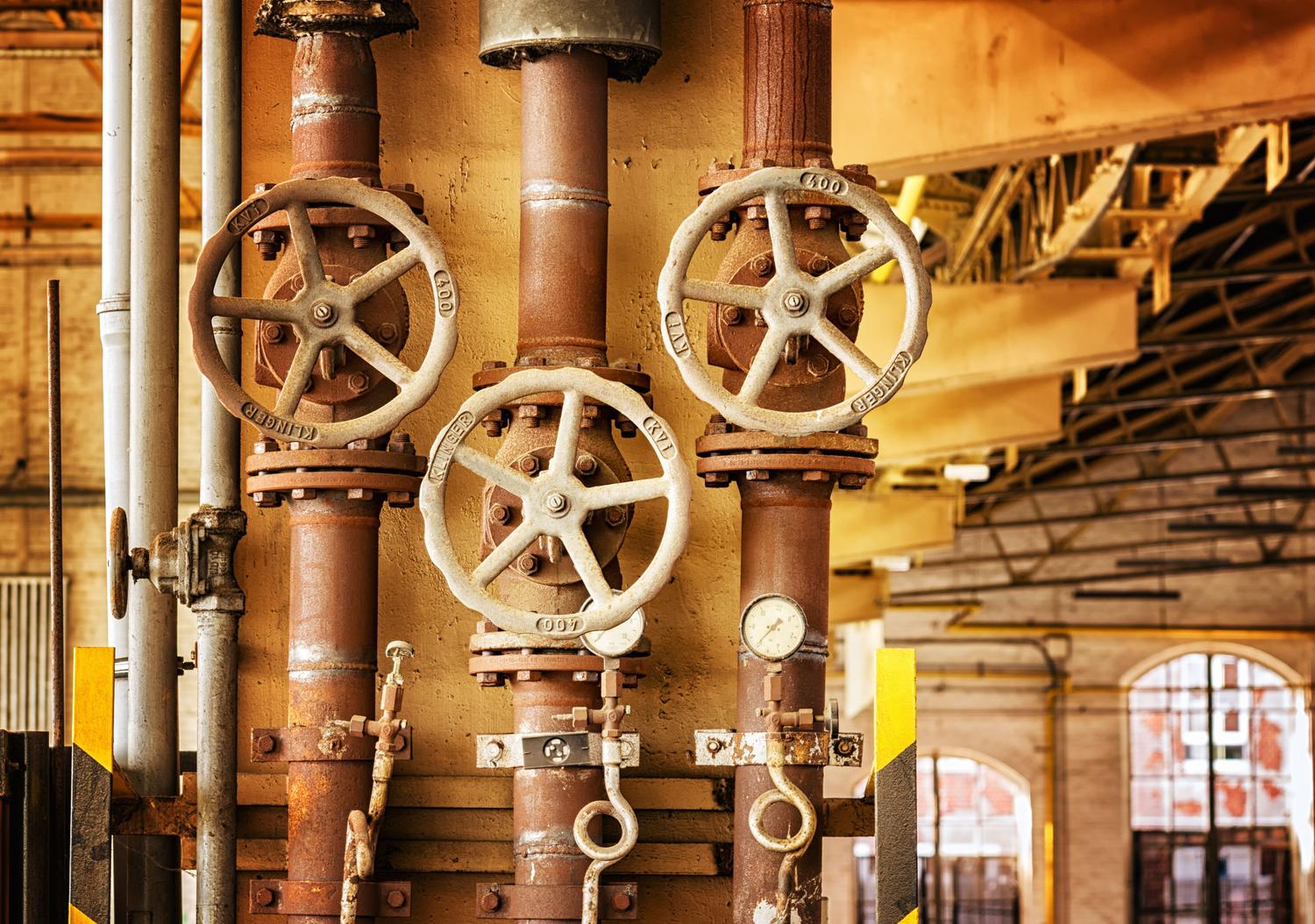 Tuberías industriales oxidadas que ilustran la necesidad de sistemas de protección catódica contra la corrosión.