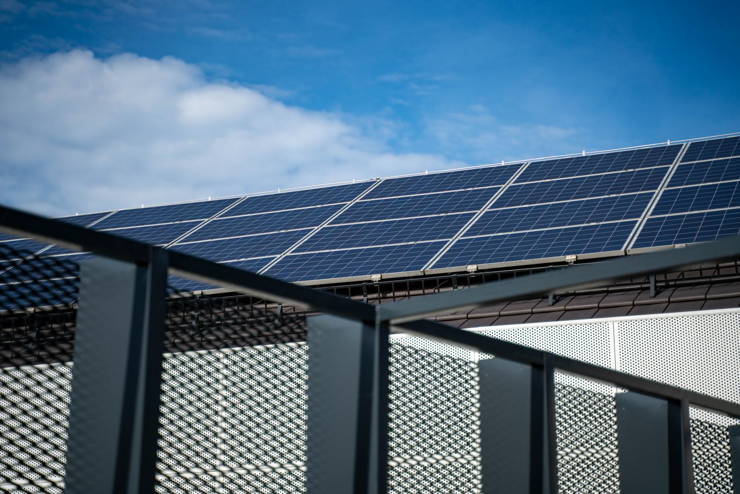Paneles solares modernos instalados en un tejado bajo un cielo azul despejado, representando la energía limpia. Paneles solares modernos instalados en un tejado bajo un cielo azul despejado, representando la energía limpia.