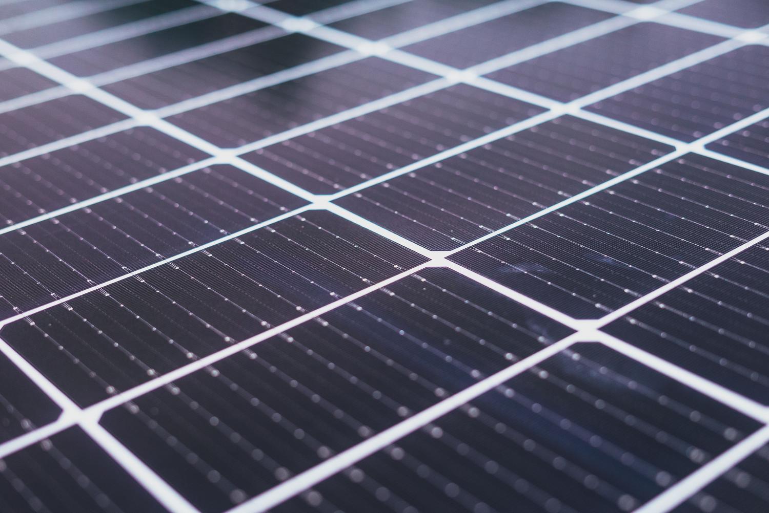Primer plano detallado de las células de un panel solar, resaltando la tecnología fotovoltaica y su eficiencia.