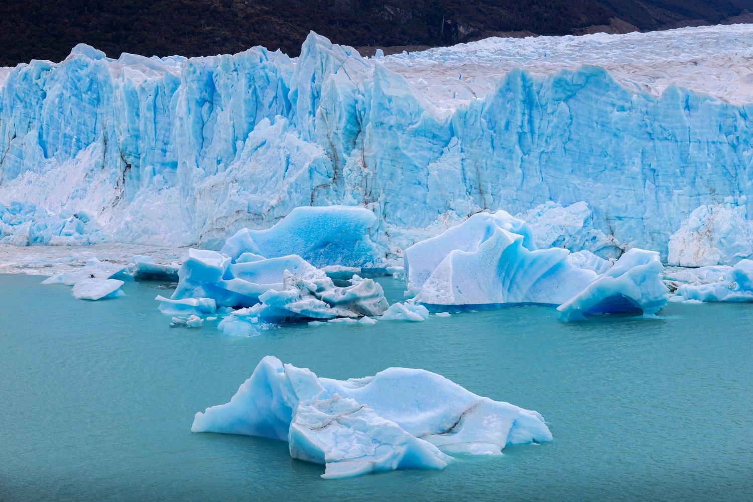 Glaciar derritiéndose con icebergs flotando, mostrando el impacto del calentamiento global provocado por los gases de efecto invernadero como el metano.