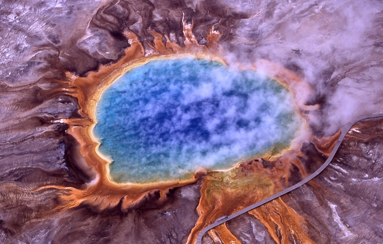 Vista aérea de la fuente termal Grand Prismatic Spring, mostrando los colores vibrantes del calor geotérmico natural.