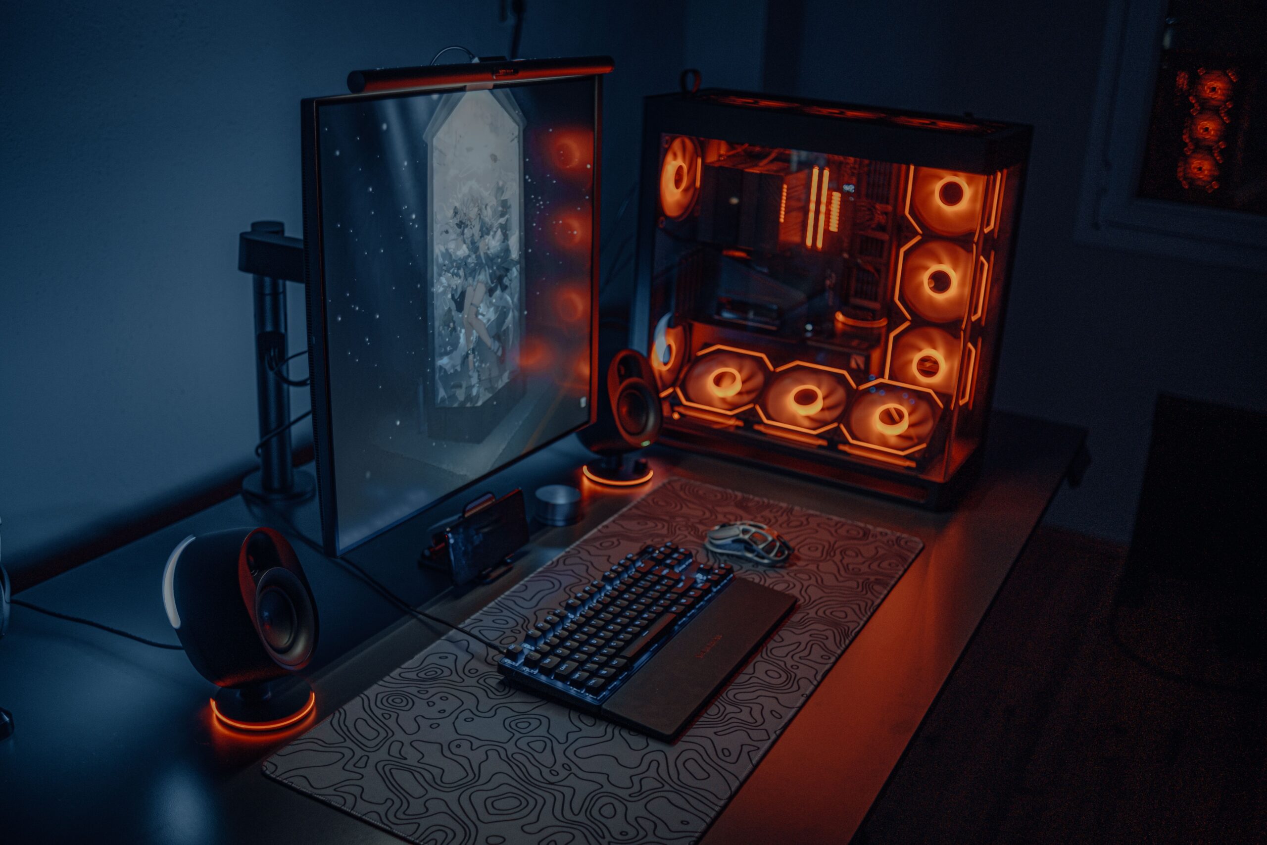 Configuración de escritorio gaming con iluminación RGB personalizada y ventiladores LED en la torre del PC