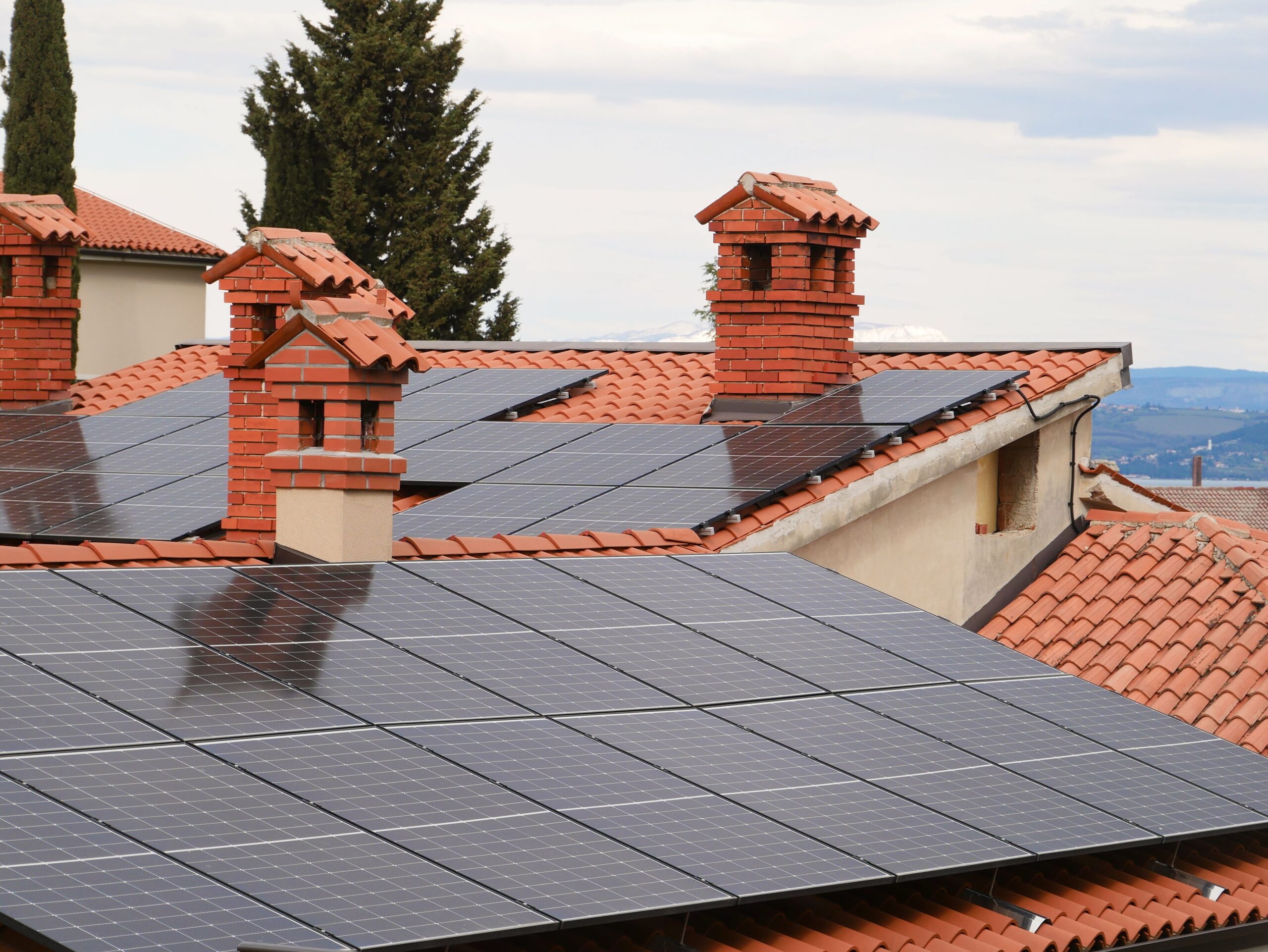 Vista aérea de tejados residenciales con instalaciones de paneles solares fotovoltaicos integrados en la arquitectura tradicional.