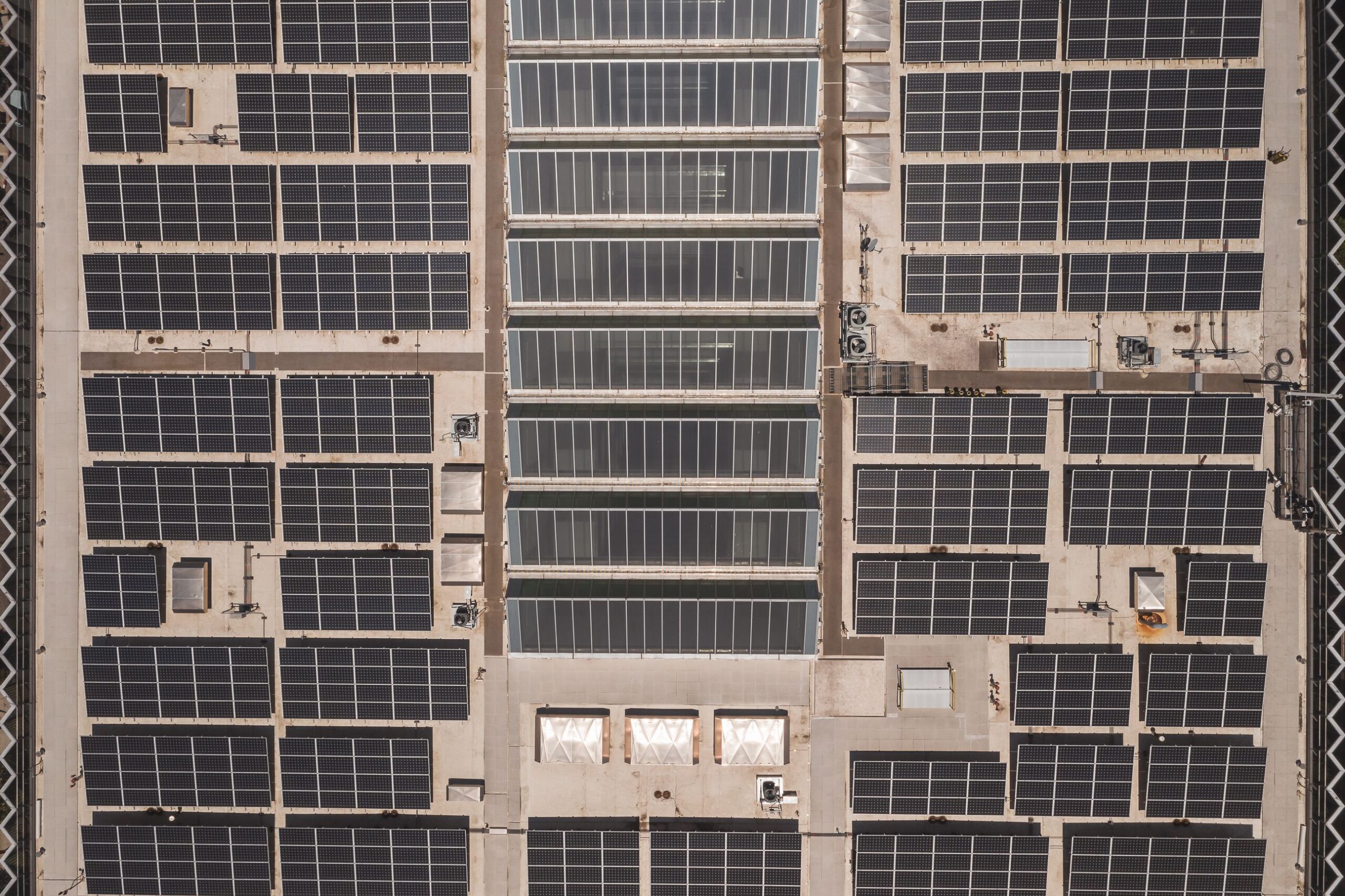 Instalación a gran escala de paneles solares en la cubierta de un edificio industrial, ejemplificando el despliegue fotovoltaico para empresas.