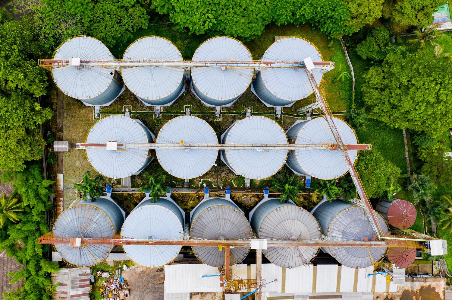 Vista aérea de una planta de biogás con silos industriales integrados en un entorno boscoso, simbolizando la inversión en energía sostenible.