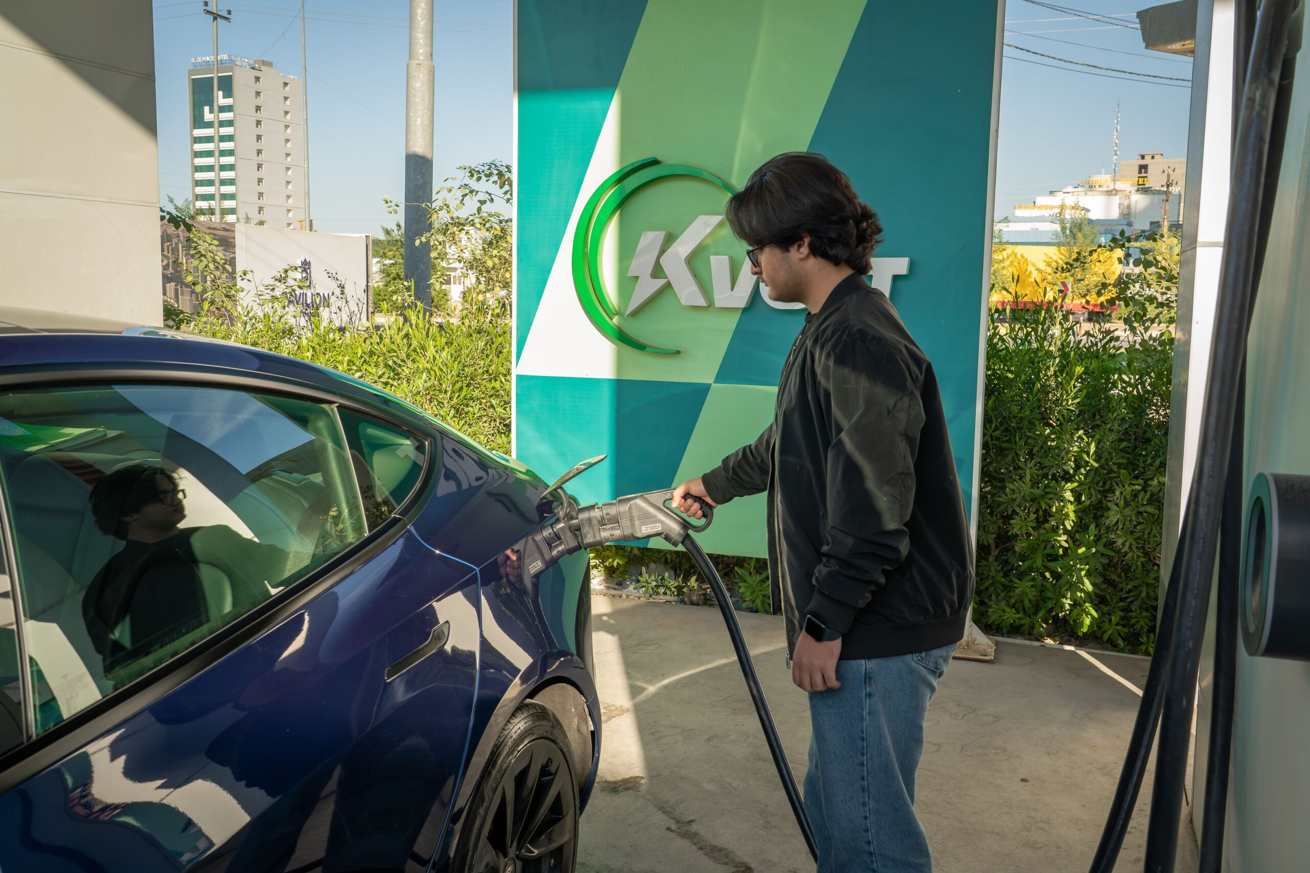 Usuario cargando su vehículo eléctrico en una estación pública, ilustrando la normalización del uso de coches cero emisiones.