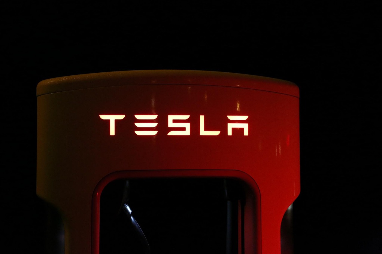 Estación de carga rápida de Tesla durante la noche, resaltando la red de carga eficiente para viajes de media y larga distancia.
