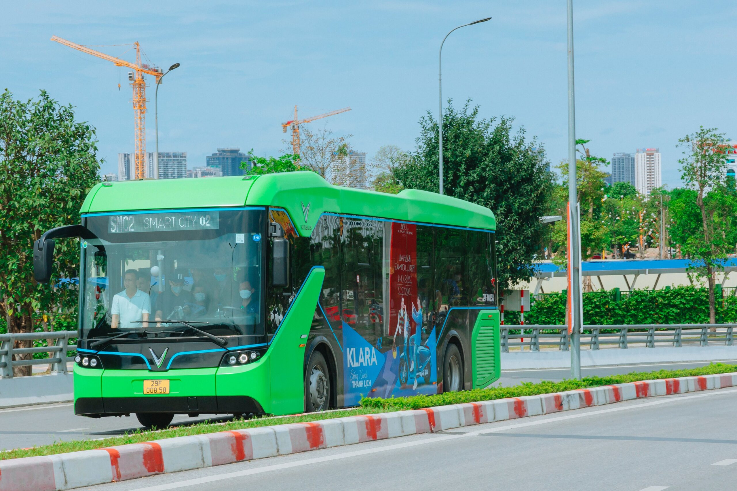 Autobús eléctrico moderno de color verde con el letrero 'Smart City', ilustrando el transporte urbano sostenible y limpio.