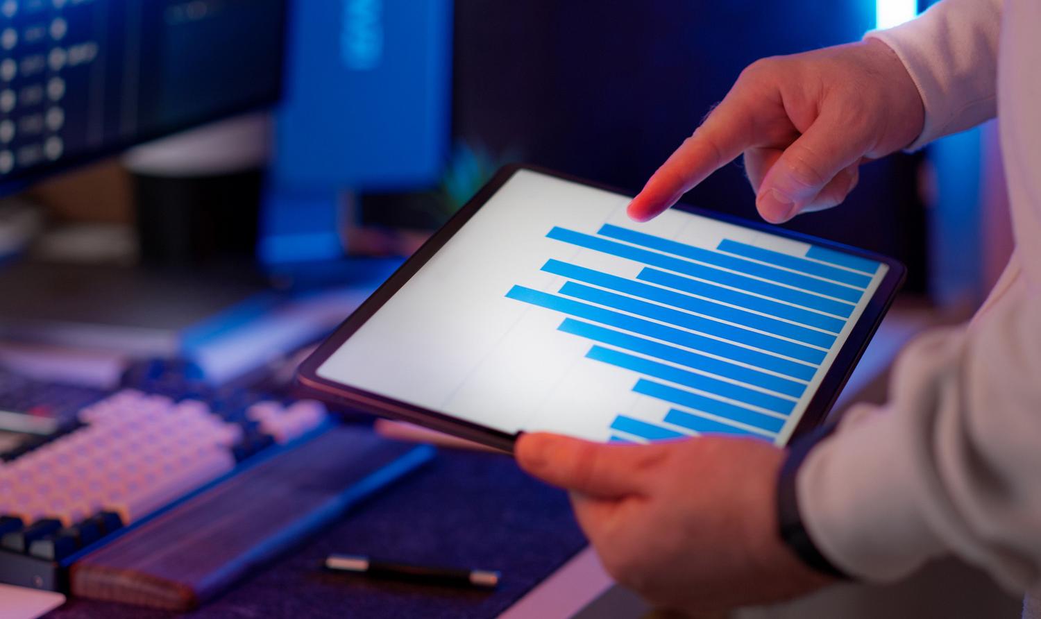 Profesional analizando datos de consumo energético a través de un gráfico en una tablet para realizar un diagnóstico eficiente.