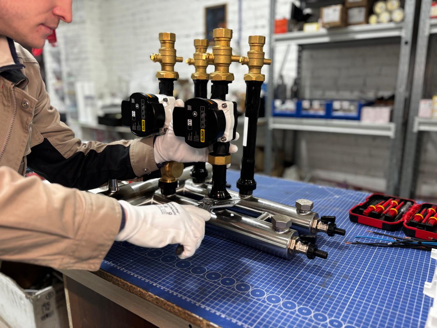 Ingeniero ensamblando un sistema de tuberías y válvulas de una unidad de calefacción industrial para la generación de calor.