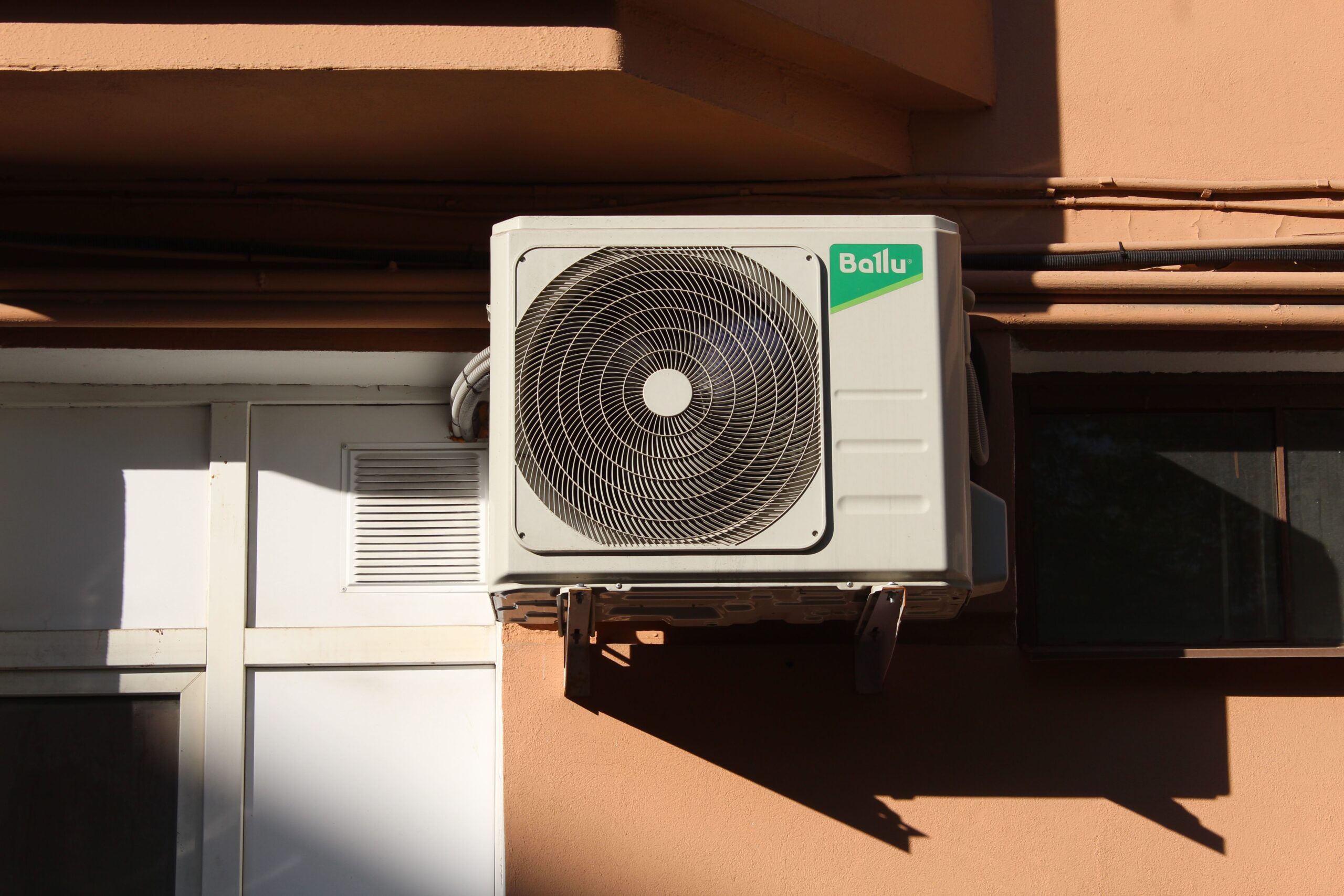 Unidad condensadora de aire acondicionado instalada en el exterior de un edificio.