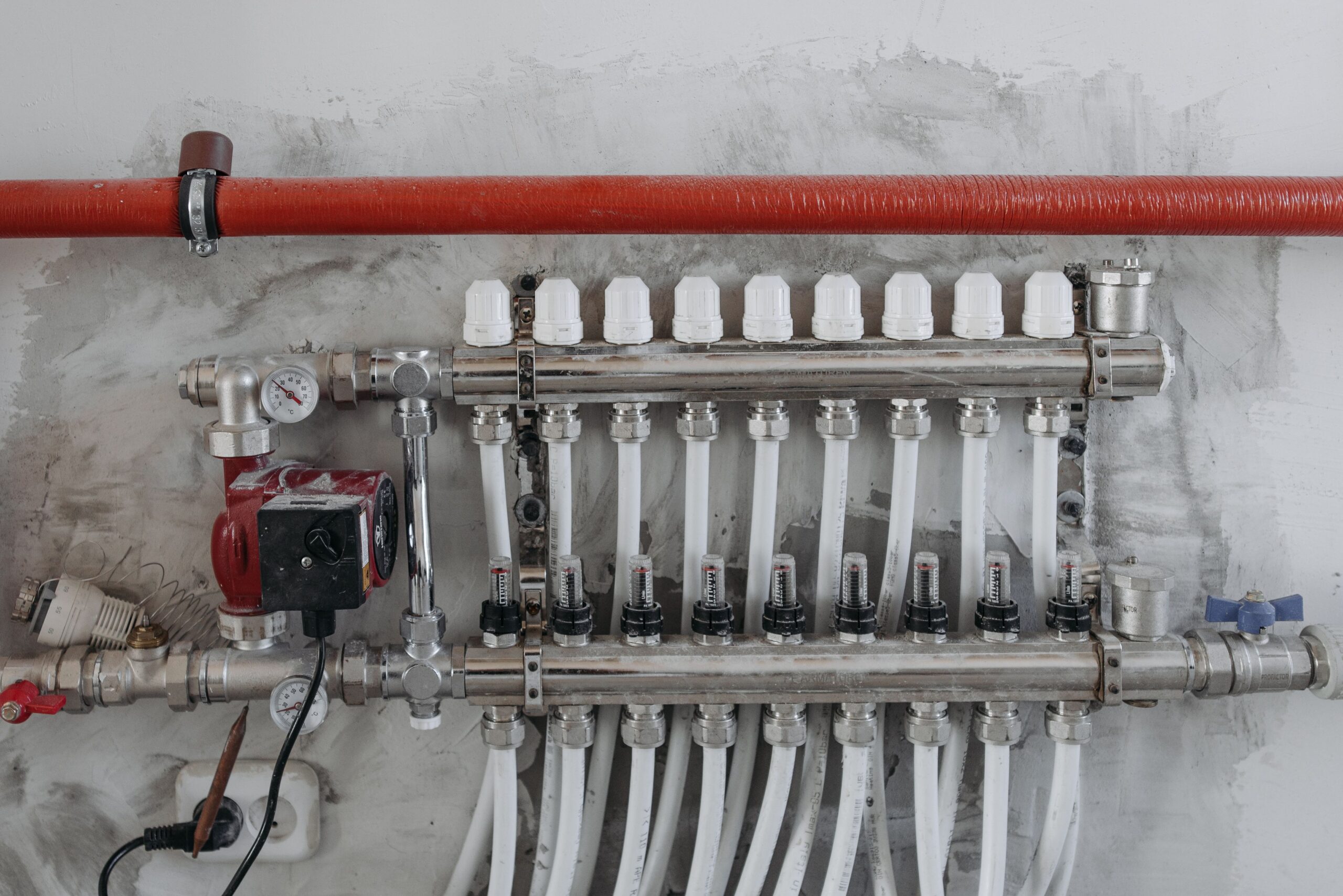 Primer plano de manómetros industriales y colectores de acero inoxidable para el control de presión en circuitos de climatización.