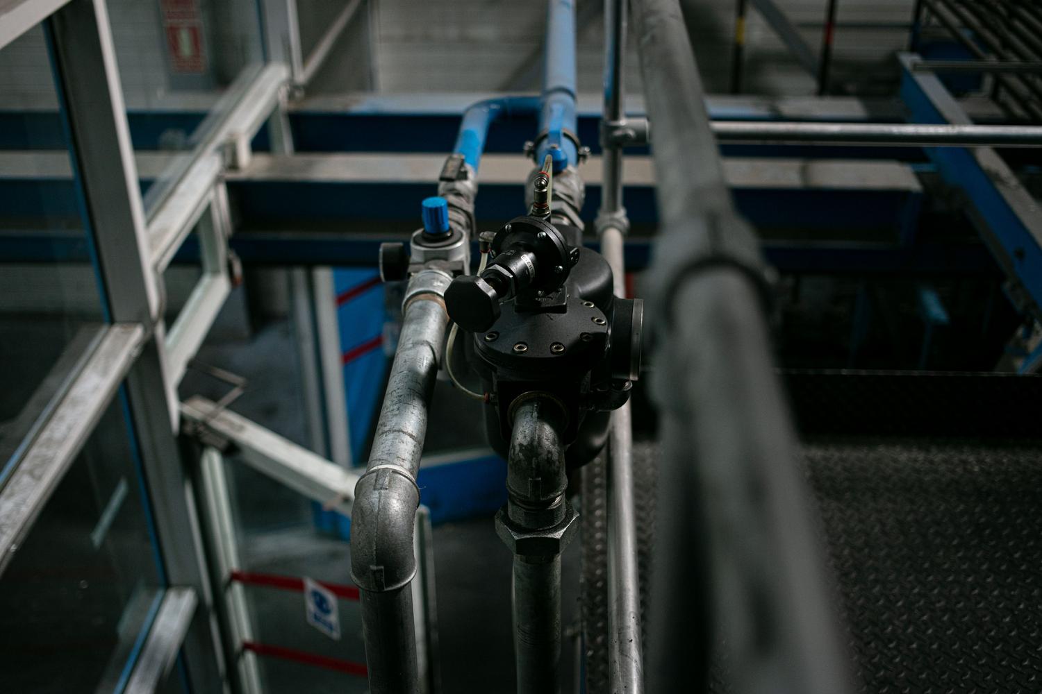 Detalle de un sistema de tuberías metálicas con válvulas en una instalación industrial.