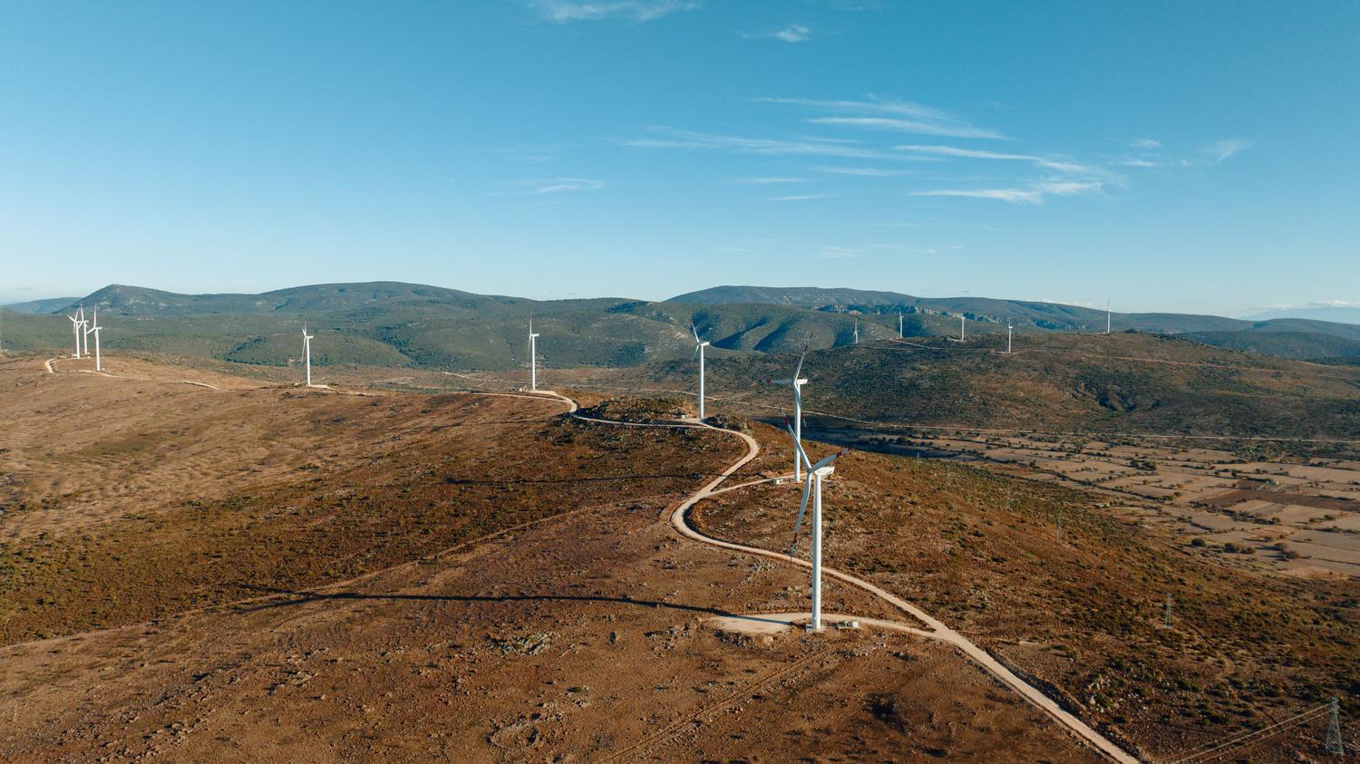 Vista aérea de caminos de acceso en un parque eólico, representando la fase de ingeniería, construcción y logística de un proyecto eólico. Vista aérea de caminos de acceso en un parque eólico, representando la fase de ingeniería, construcción y logística de un proyecto eólico.