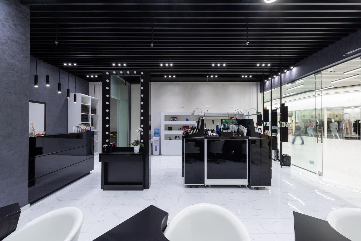 Salón de belleza moderno y espacioso con iluminación elegante, resultado de una reforma integral