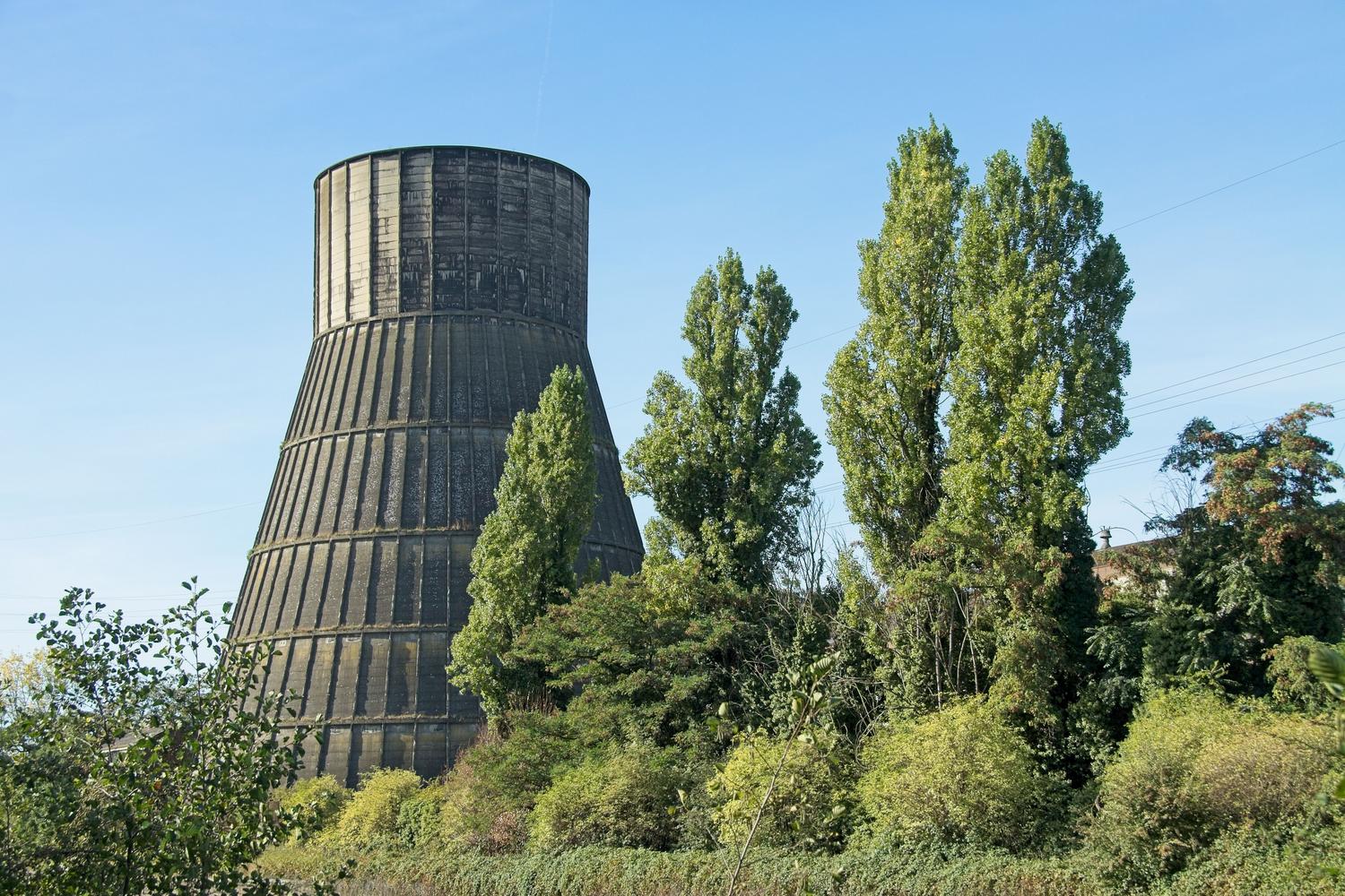 Torre de refrigeración industrial en un entorno soleado, ideal para ilustrar la disipación de calor en climas cálidos.