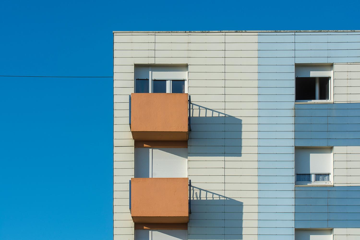 Fachada de edificio residencial moderno y eficiente con diseño arquitectónico sostenible.