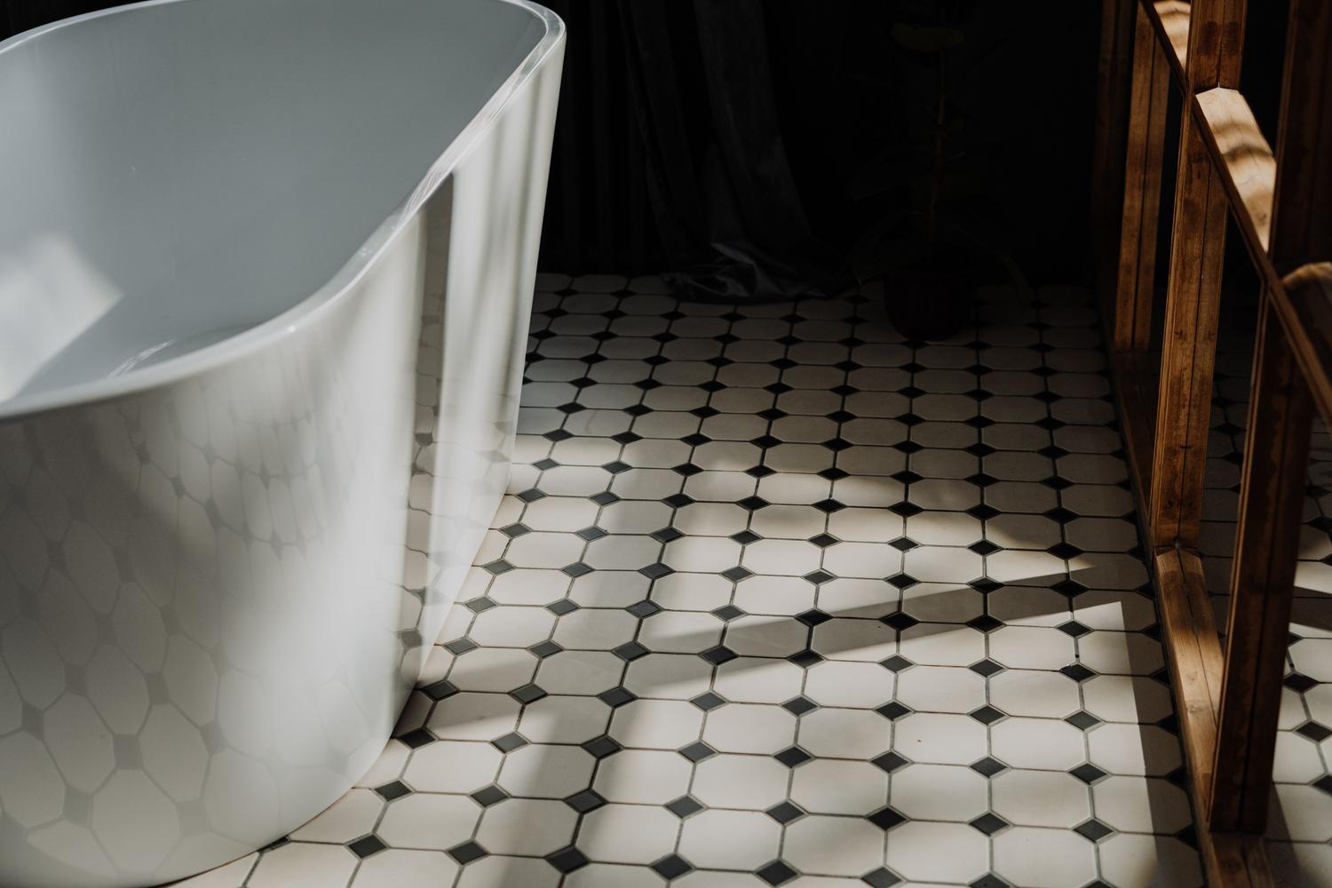 Baño minimalista con azulejos hexagonales en el suelo, combinando higiene, seguridad y diseño moderno.