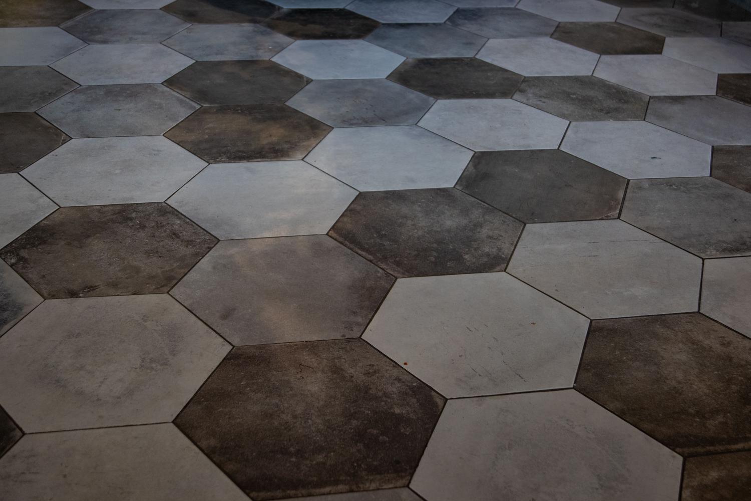 Suelo de porcelánico con patrón de mármol en piezas hexagonales, perfecto para zonas que requieren alta durabilidad y limpieza.