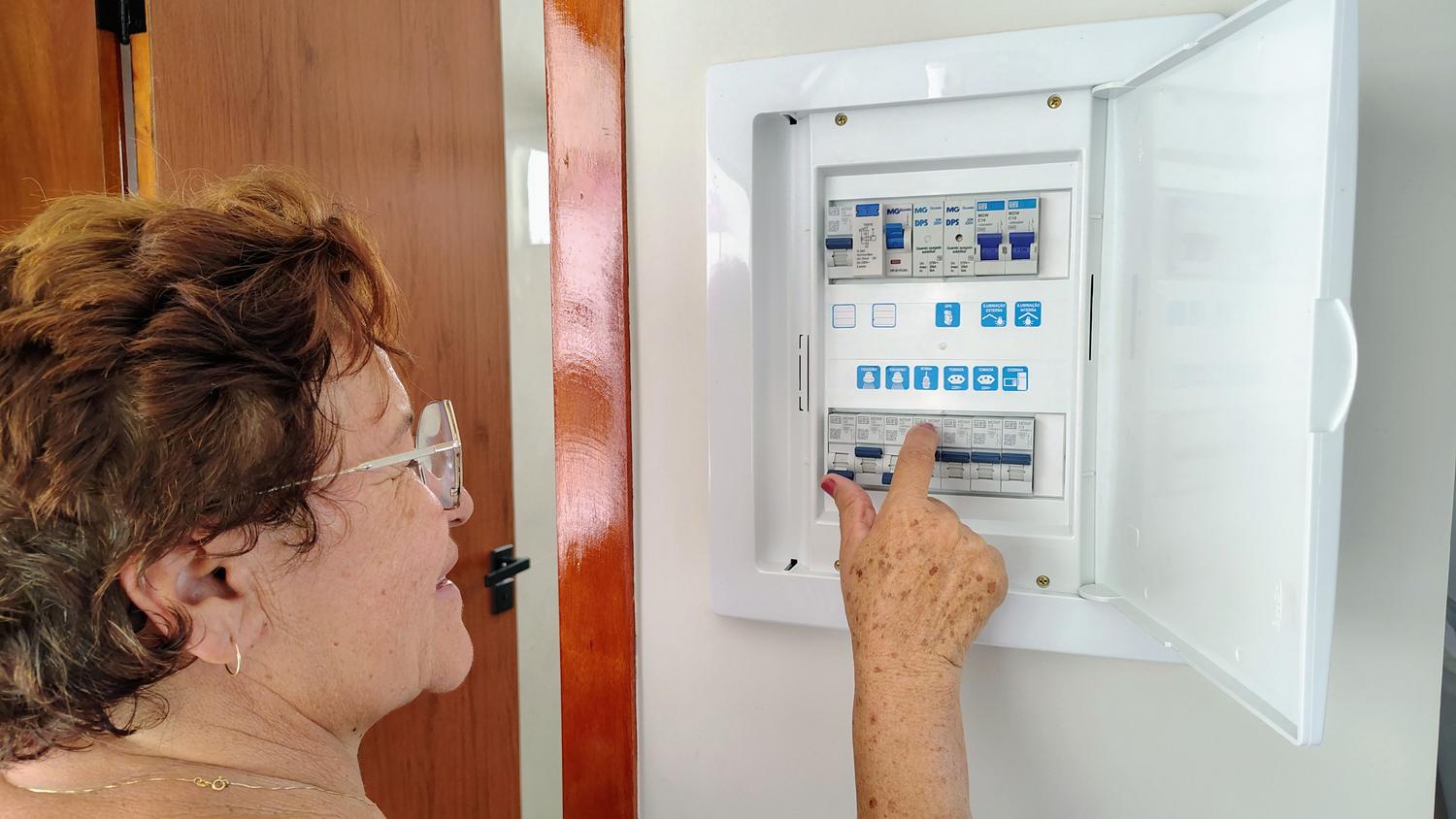 Persona revisando el cuadro eléctrico de la vivienda, representando el concepto de potencia y el salto de los plomos.